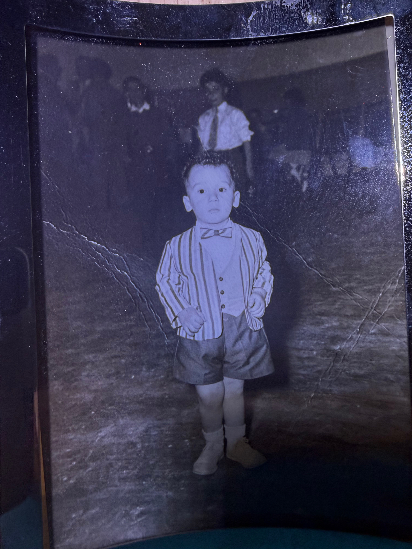Young Joe Colangelo as a boy in a striped jacket, waistcoat and bow tie at a family gathering