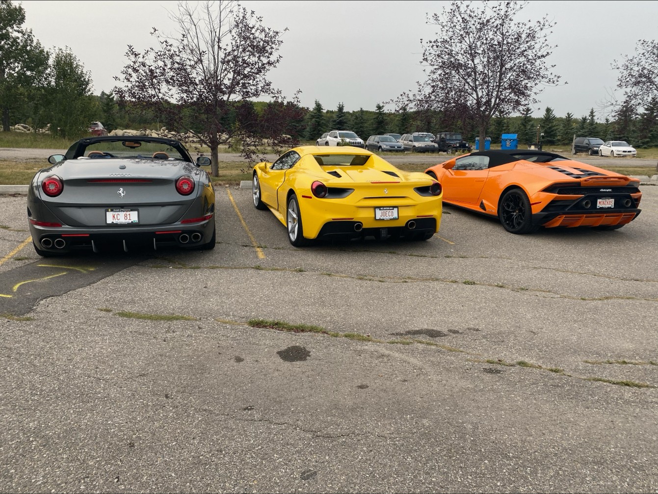 Three of Joe Colangelo's cars parked side by side: a grey Ferrari California, a yellow Ferrari 488 Spider and an orange Lamborghini Huracan